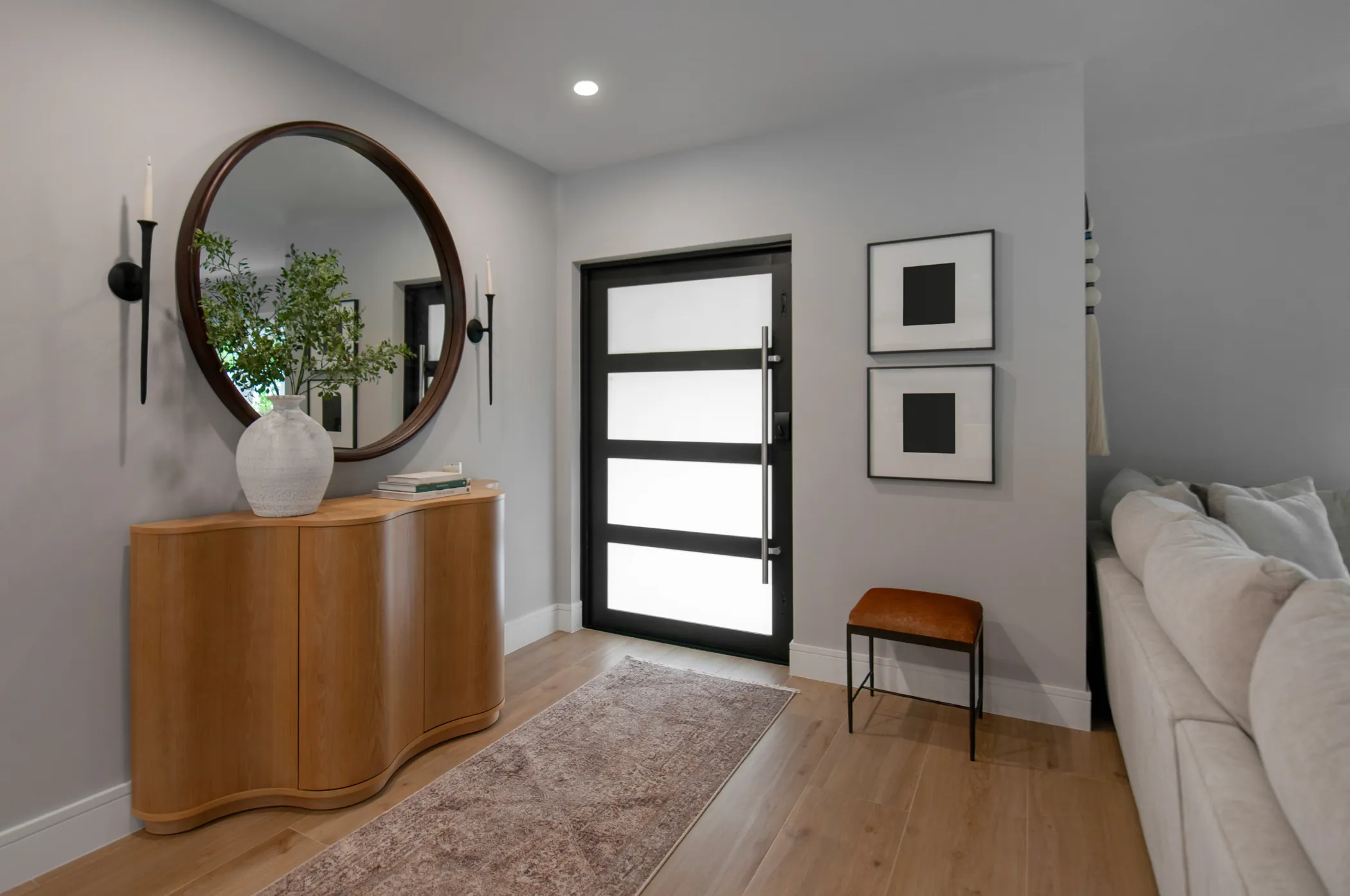 Entry foyer with round mirror and fluted credenza