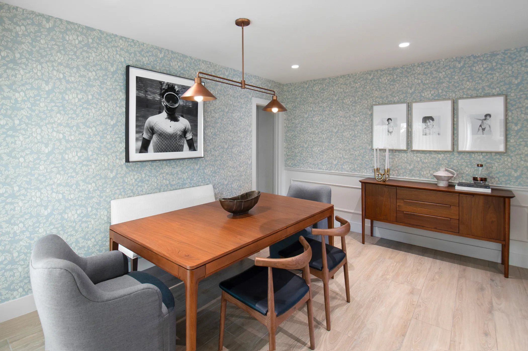 Dining room with teak table, mid-century chairs, and patterned wallpaper