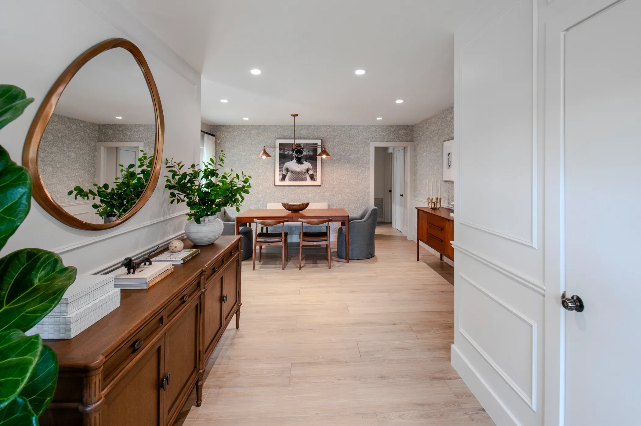 Entry hall with round mirror and vintage credenza