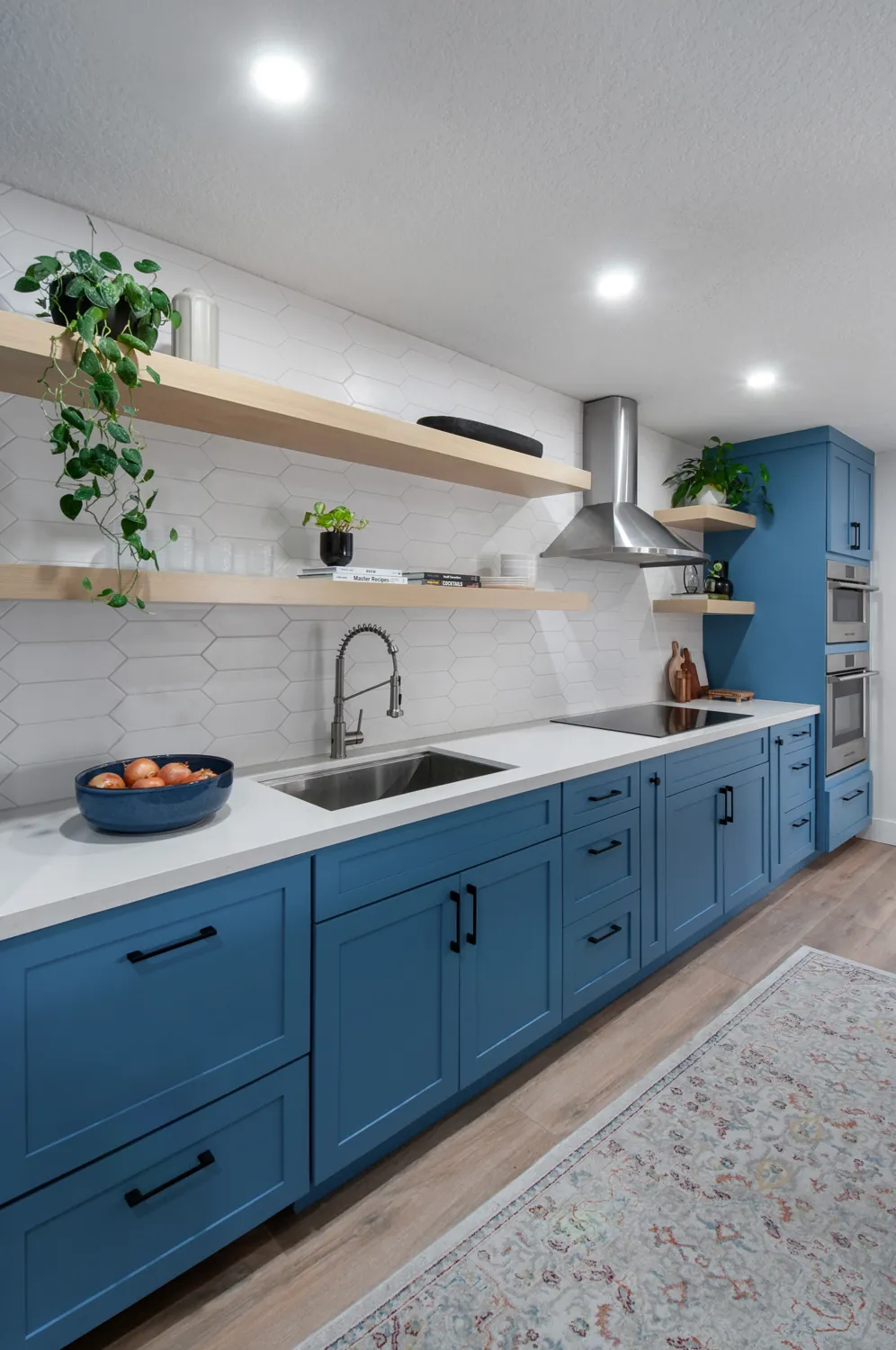 Blue cabinetry with floating oak shelves