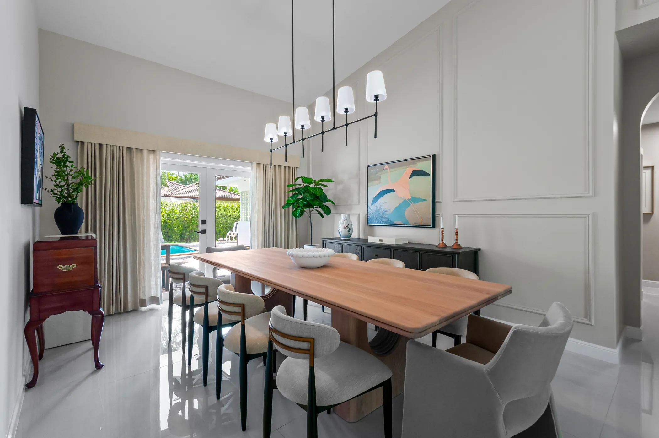 Dining room with trim-paneled wall and linear chandelier