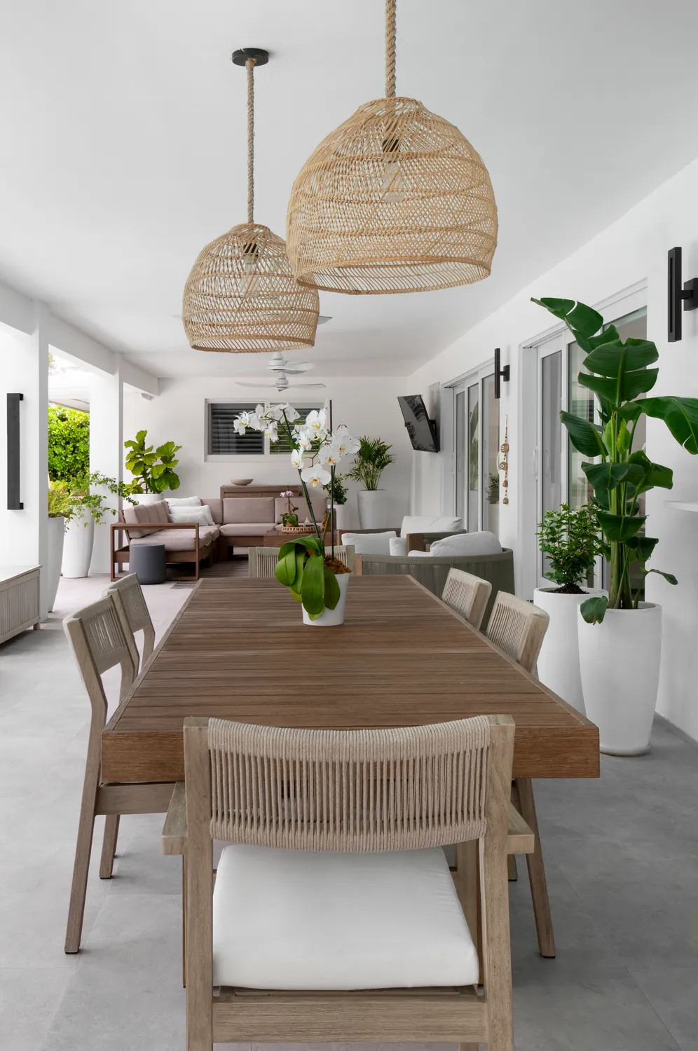 The dining table under rattan pendants
