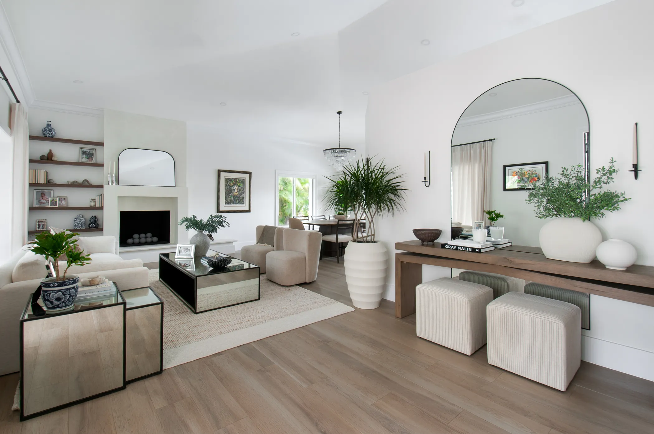 Cream living room with arched mirror, fireplace, and layered neutrals